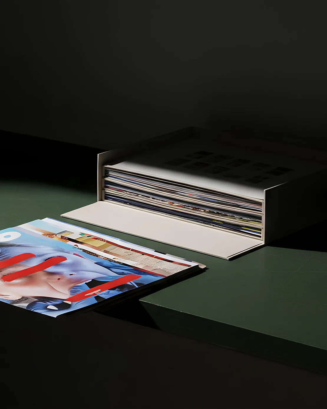 Cofanetto da collezione ACIDO aperto e magazines appoggiati su una mensola verde poco.