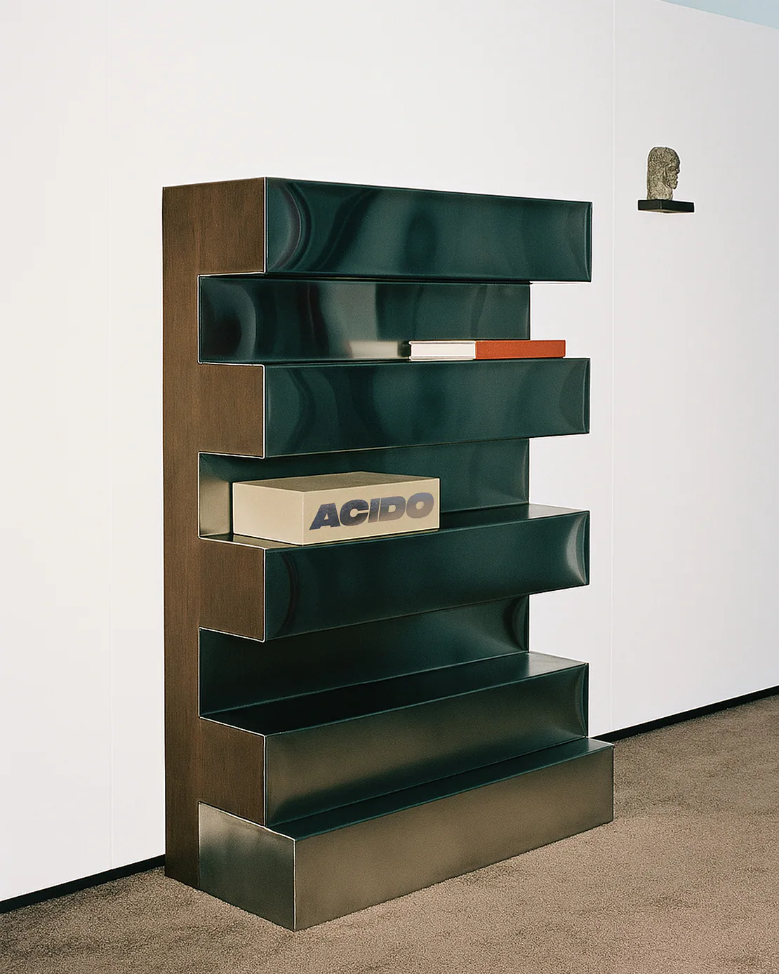 Cofanetto da collezione ACIDO riposto su una libreria moderna a mensole scultoree, in un ambiente minimale.