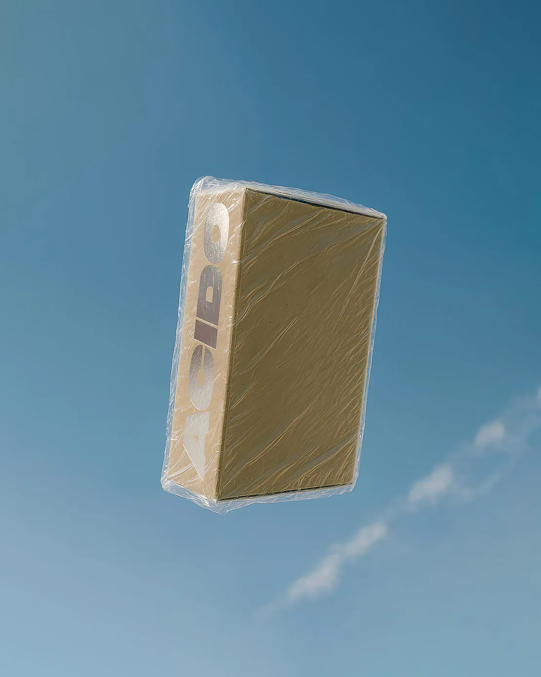 Cofanetto da collezione ACIDO avvolto in plastica trasparente sospesa contro il cielo azzurro.