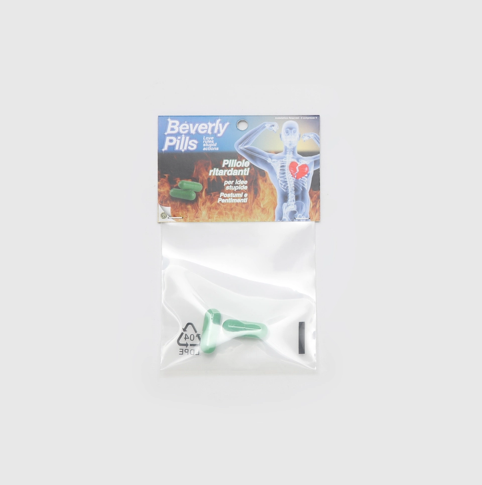 Confezione di Beverly Pills con la scritta 'Love rules, stupid actions'. Pillole verdi pensate per ironicamente rallentare cattive scelte amorose e ridurre i postumi emotivi.