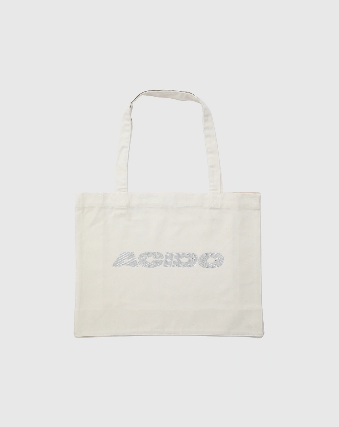 Totebag bianca con il logo 'ACIDO' decorato con brillantini argentati al centro.