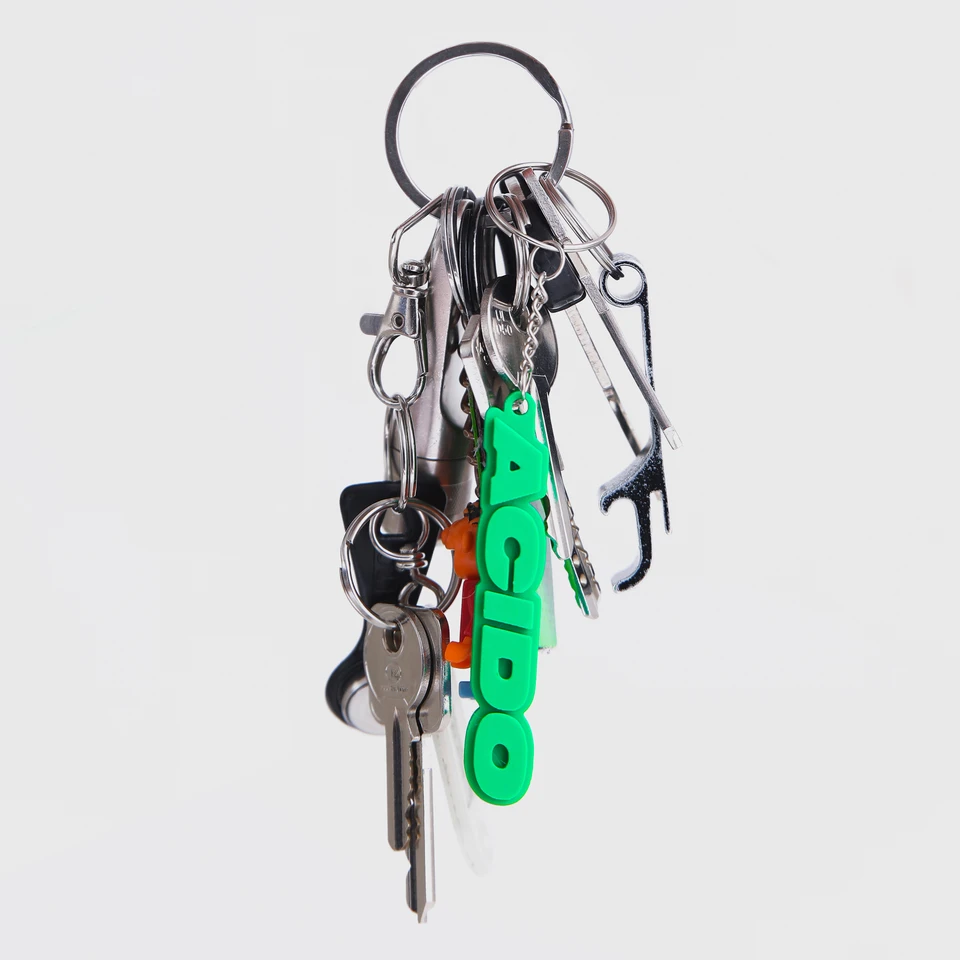 Dettaglio di un mazzo di chiavi con il portachiavi verde 'ACIDO'.