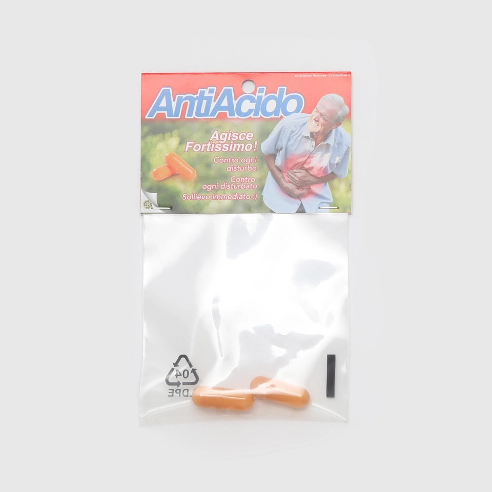 Confezione di Antiacido Pills con un design ironico e la scritta 'Agisce Fortissimo!' contro disturbi e disturbi d'animo. Include due pillole arancioni.
