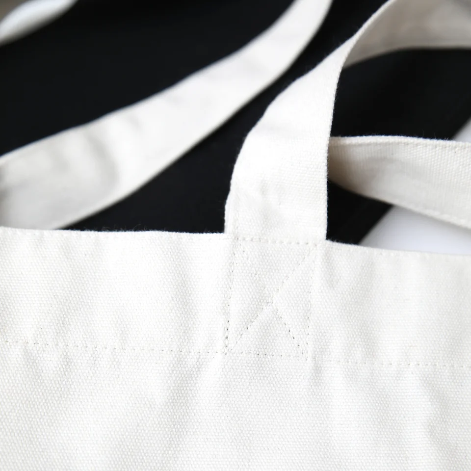 Dettaglio delle cuciture della Totebag bianca, che mostra la robustezza delle maniglie.