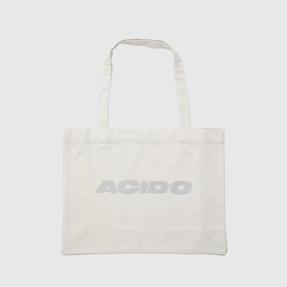 Totebag bianca con il logo 'ACIDO' decorato con brillantini argentati al centro.